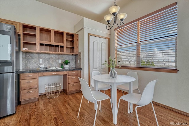 dining space with wood finished floors and a chandelier