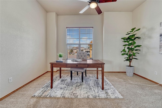 office space with carpet flooring, a ceiling fan, and baseboards