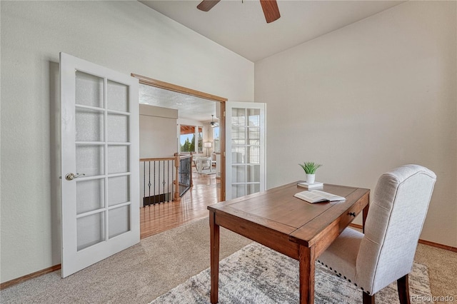 carpeted dining room with a ceiling fan and baseboards