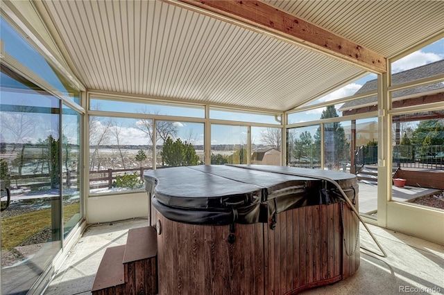 sunroom featuring lofted ceiling with beams