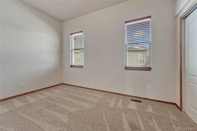 empty room with visible vents, baseboards, and carpet floors