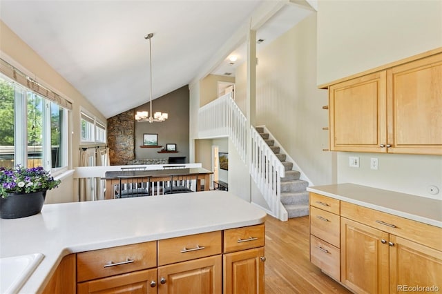 6083 S Glencoe Way, Centennial, CO 80121 - kitchen with light wood-style flooring, a chandelier, a peninsula, light countertops, and pendant lighting