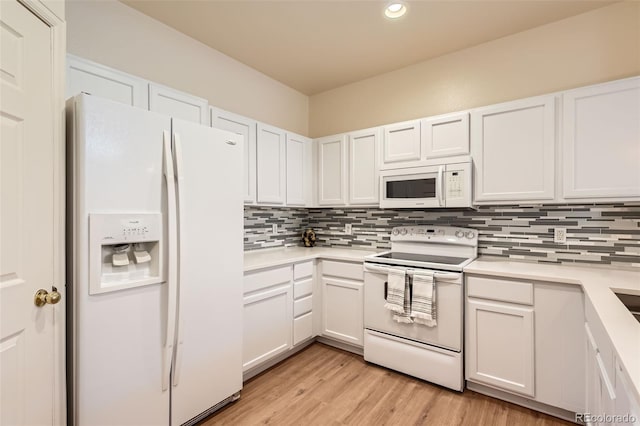 kitchen with white appliances, decorative backsplash, light countertops, recessed lighting, and white cabinets