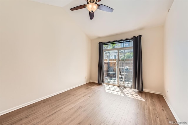 empty room featuring wood finished floors, lofted ceiling, baseboards, and ceiling fan