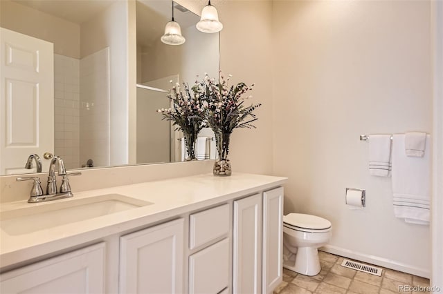 bathroom featuring toilet, a shower, baseboards, and vanity
