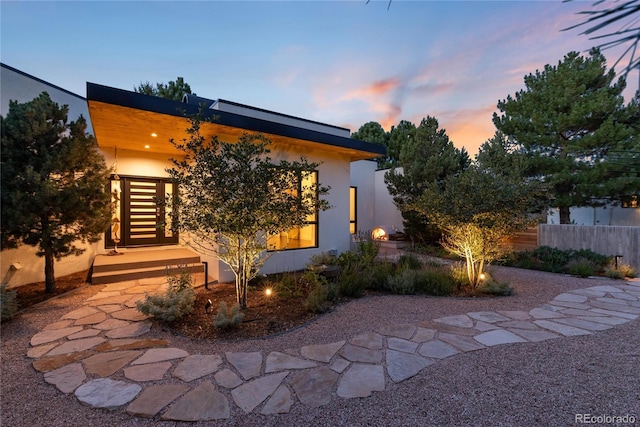 back house at dusk featuring a patio area