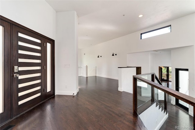 foyer entrance featuring dark wood-type flooring and a high ceiling