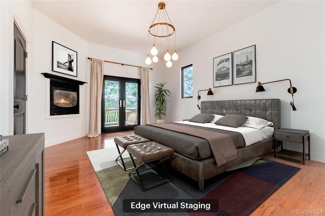 bedroom with french doors, a chandelier, access to outside, and light hardwood / wood-style flooring