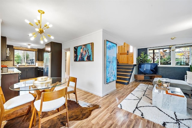 dining area featuring a notable chandelier, stairway, baseboards, and light wood-style floors