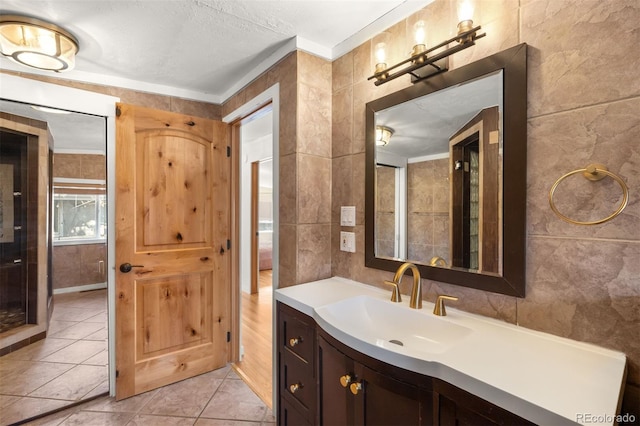 bathroom with tile walls, vanity, and tile patterned floors