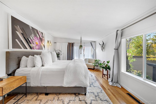 bedroom with light wood finished floors, baseboards, and visible vents