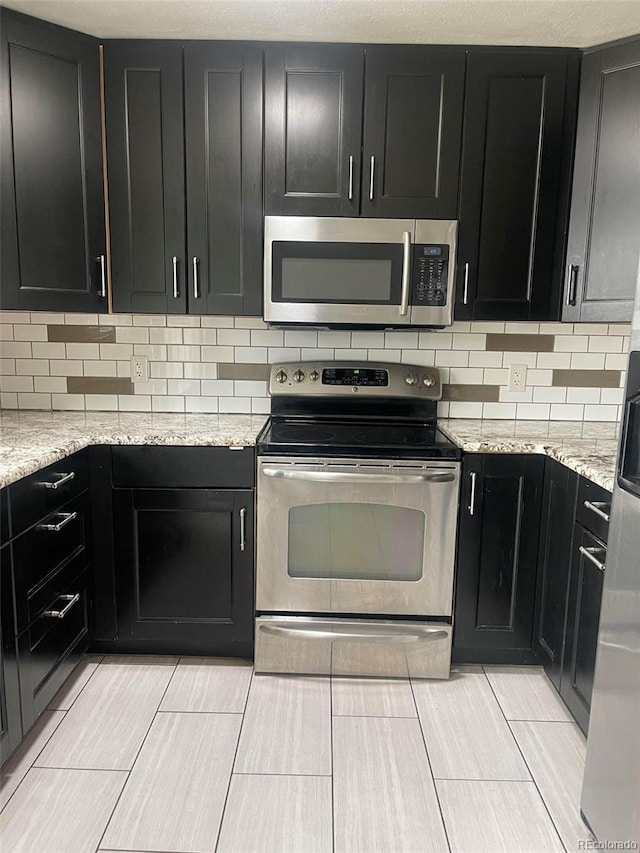 kitchen with light stone counters and stainless steel appliances