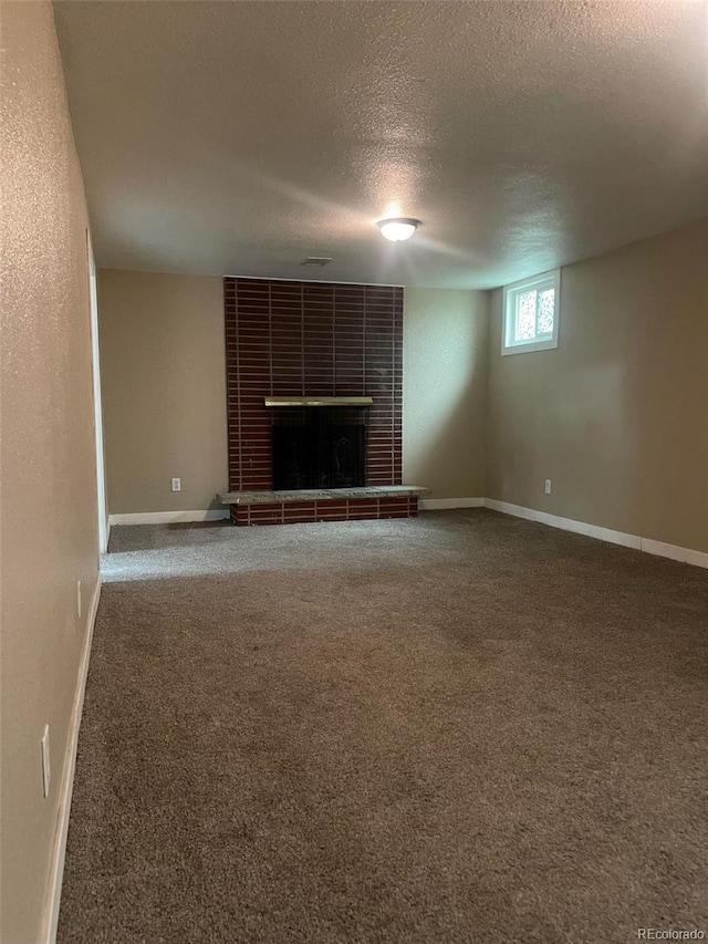 unfurnished living room featuring carpet, a tile fireplace, and a textured ceiling