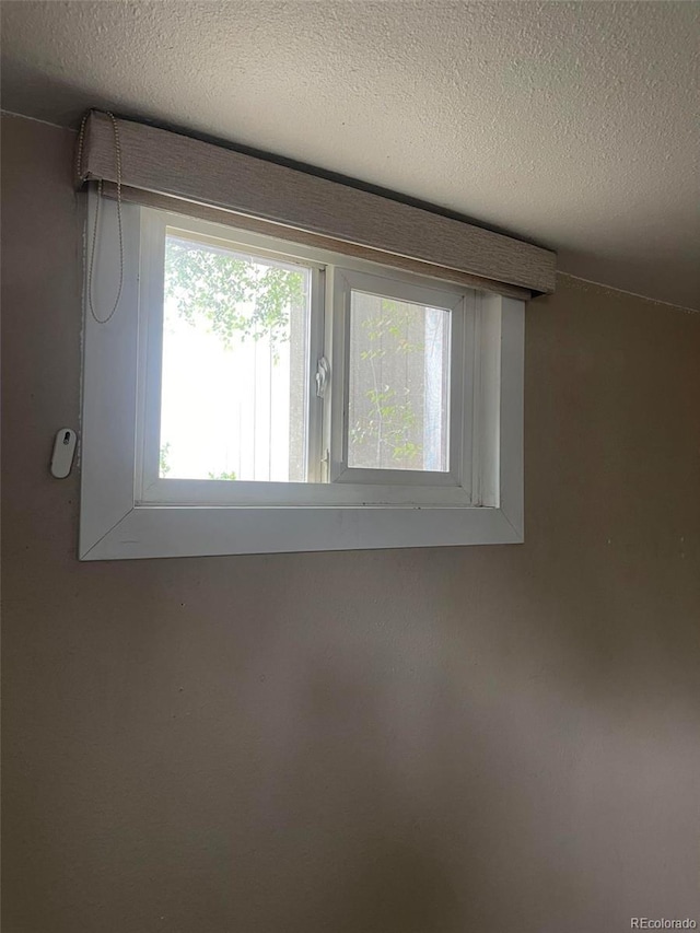 unfurnished room with a textured ceiling