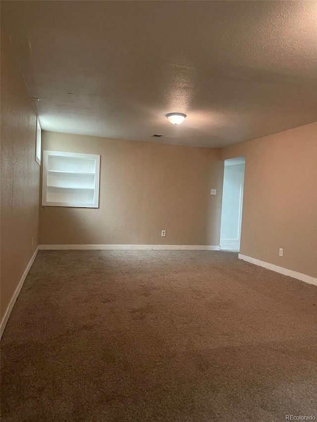 empty room with a textured ceiling and carpet