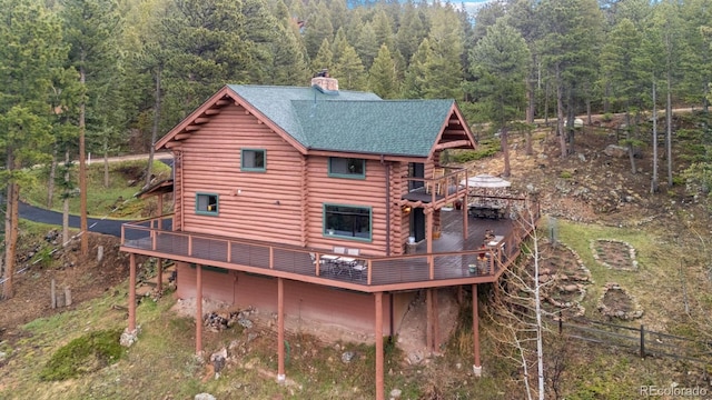 6241 Kilimanjaro Dr, Evergreen, CO 80439 - back of property with a view of trees, a chimney, log exterior, and a wooden deck