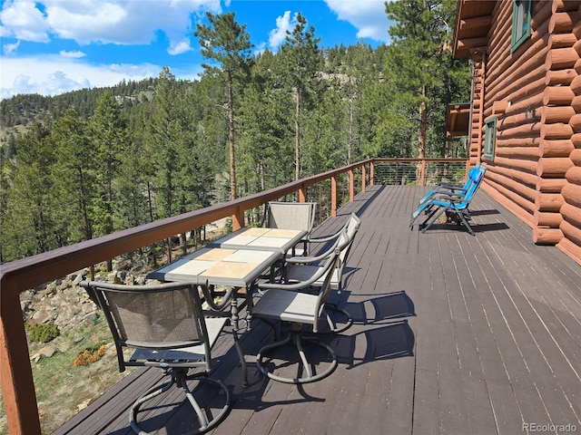 6241 Kilimanjaro Dr, Evergreen, CO 80439 - wooden terrace with a forest view and outdoor dining area