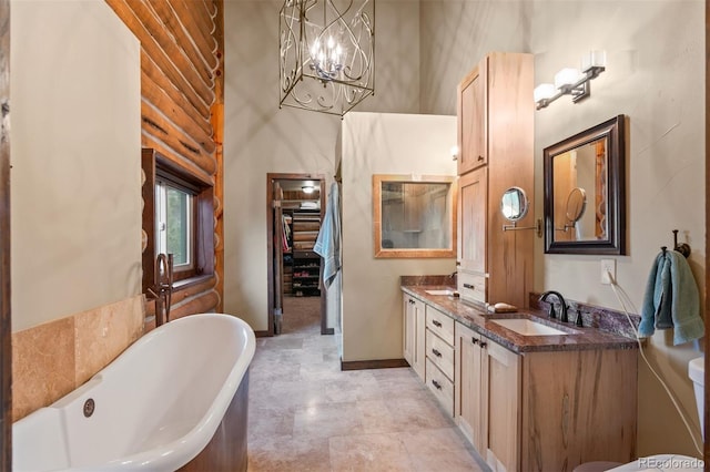 6241 Kilimanjaro Dr, Evergreen, CO 80439 - bathroom with a soaking tub, double vanity, a chandelier, and baseboards