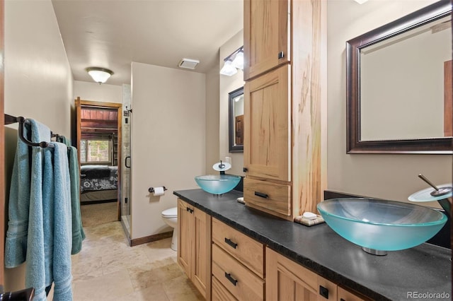 6241 Kilimanjaro Dr, Evergreen, CO 80439 - bathroom with toilet, double vanity, ensuite bathroom, and baseboards
