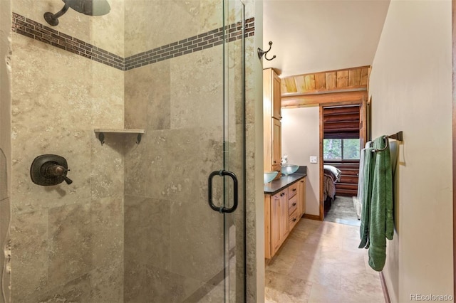 6241 Kilimanjaro Dr, Evergreen, CO 80439 - ensuite bathroom featuring a stall shower, vanity, ensuite bath, and baseboards