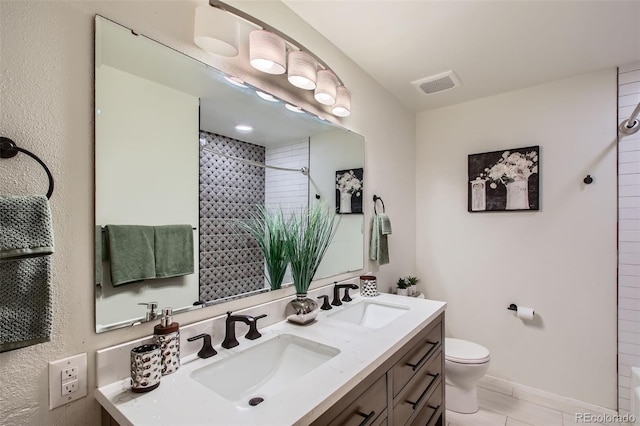bathroom with a sink, double vanity, toilet, and visible vents