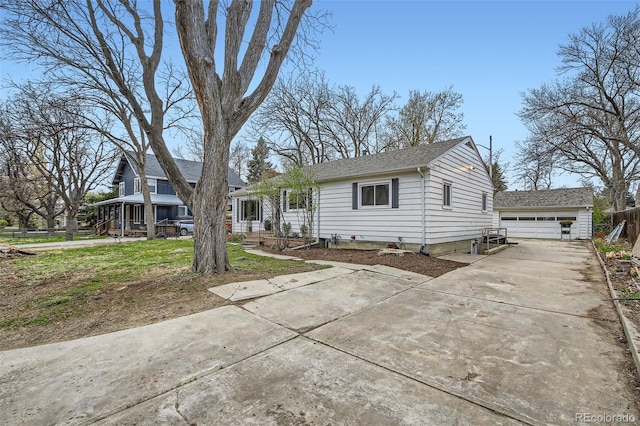 view of front of house featuring an outdoor structure, a garage, and a shingled roof