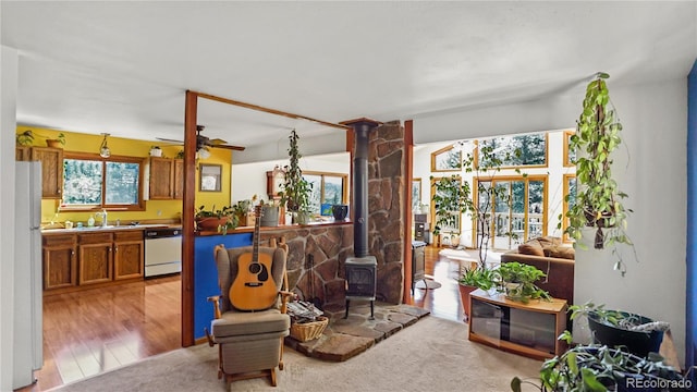 1269 Roland Dr, Bailey, CO 80421 - kitchen featuring white appliances, a wood stove, brown cabinets, a ceiling fan, and a sink