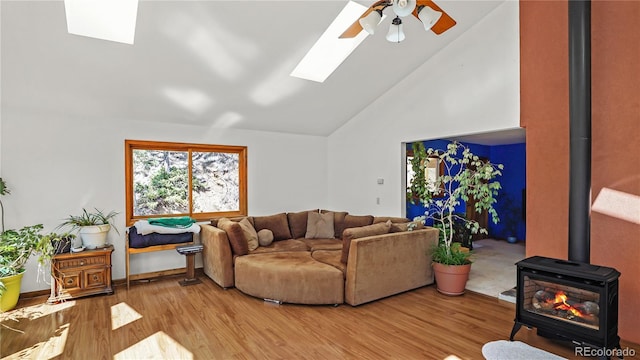 1269 Roland Dr, Bailey, CO 80421 - living area featuring a skylight, a wood stove, ceiling fan, wood finished floors, and high vaulted ceiling