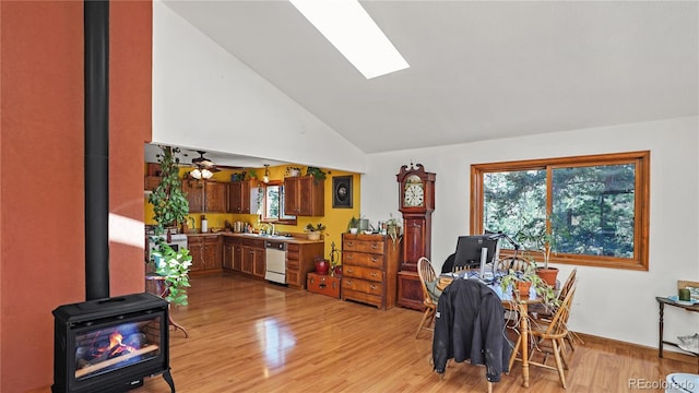 1269 Roland Dr, Bailey, CO 80421 - living area with a wood stove, light wood-type flooring, a skylight, and high vaulted ceiling