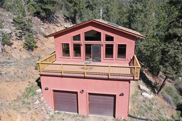 1269 Roland Dr, Bailey, CO 80421 - chalet / cabin with an attached garage, stucco siding, a wooden deck, and a forest view