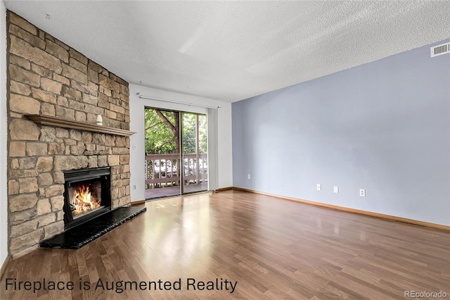 8225 Fairmount Dr Unit 102, Denver, CO 80247 - unfurnished living room featuring wood finished floors, a stone fireplace, and a textured ceiling