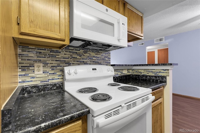 8225 Fairmount Dr Unit 102, Denver, CO 80247 - kitchen featuring white appliances, tasteful backsplash, dark countertops, and wood finished floors