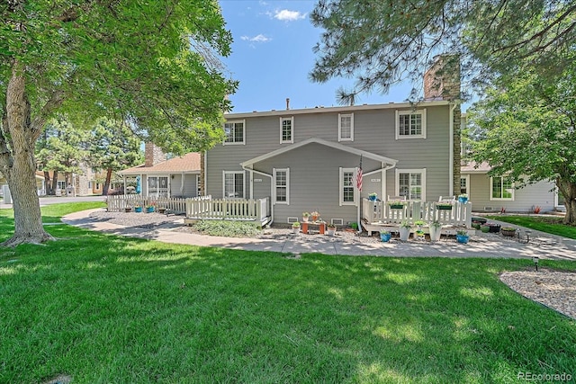 8438 Everett Way Unit B, Arvada, CO 80005 - back of property with a chimney, a deck, and a lawn