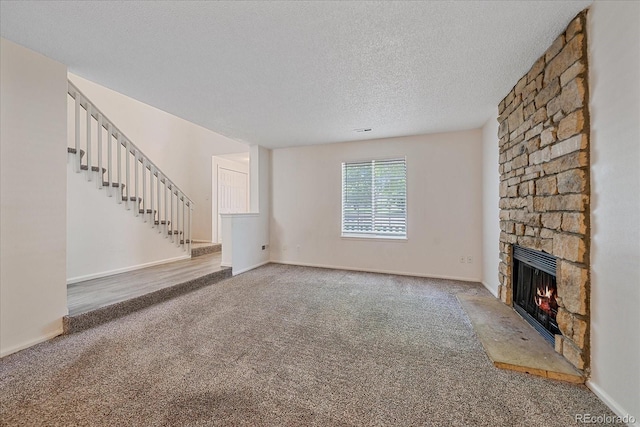 8438 Everett Way Unit B, Arvada, CO 80005 - unfurnished living room with carpet floors, stairway, a fireplace, and a textured ceiling