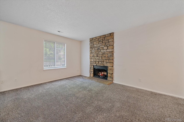 8438 Everett Way Unit B, Arvada, CO 80005 - unfurnished living room featuring a textured ceiling, carpet flooring, and a stone fireplace