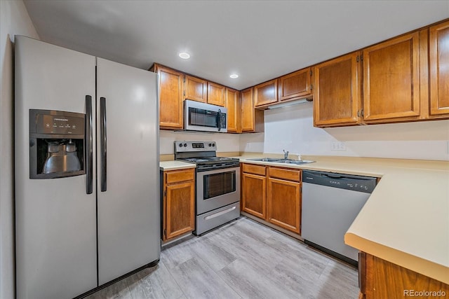 8438 Everett Way Unit B, Arvada, CO 80005 - kitchen featuring stainless steel appliances, light countertops, brown cabinets, light wood finished floors, and recessed lighting