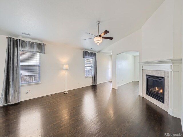 unfurnished living room with ceiling fan, a fireplace, plenty of natural light, and dark hardwood / wood-style flooring