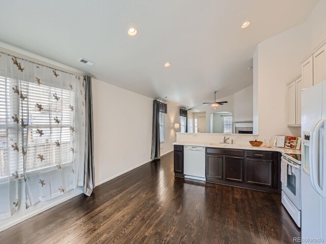 kitchen with ceiling fan, white appliances, dark brown cabinets, dark hardwood / wood-style floors, and vaulted ceiling