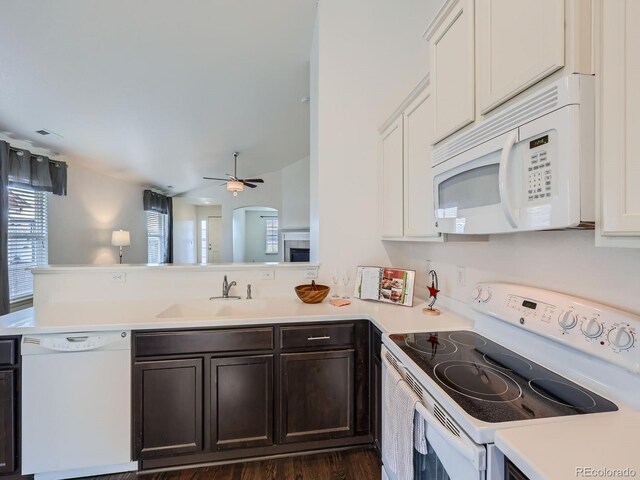 kitchen with ceiling fan, kitchen peninsula, sink, white appliances, and dark hardwood / wood-style floors