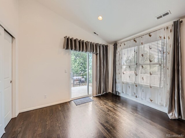 empty room with lofted ceiling and dark hardwood / wood-style flooring