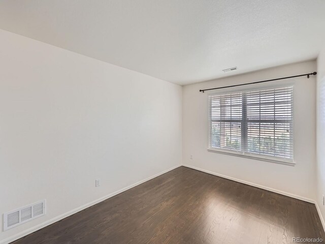 empty room featuring dark wood-type flooring