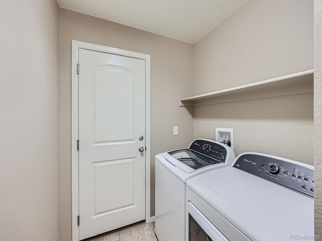 laundry area featuring washer and clothes dryer and light hardwood / wood-style floors