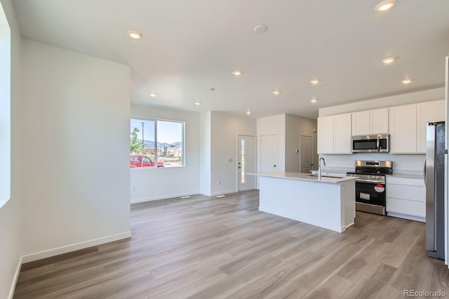 14578 W 90th Ln Unit D, Arvada, CO 80547 - kitchen with stainless steel appliances, light wood-type flooring, recessed lighting, white cabinets, and light countertops