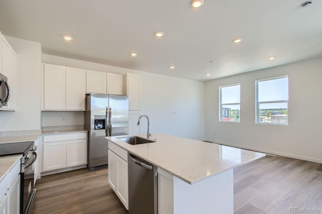 14578 W 90th Ln Unit D, Arvada, CO 80547 - kitchen with appliances with stainless steel finishes, wood finished floors, light stone counters, white cabinets, and recessed lighting