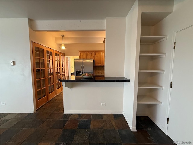 1888 S Jackson St Unit 603, Denver, CO 80210 - kitchen featuring stainless steel fridge, dark countertops, a peninsula, brown cabinetry, and dark stone finish flooring