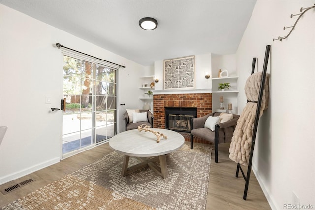 13275 W 63rd Pl, Arvada, CO 80004 - sitting room featuring wood finished floors and a brick fireplace