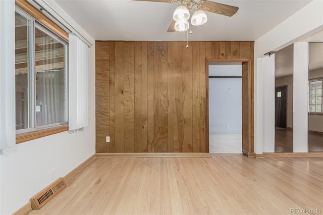 3334 W Grand Ave, Englewood, CO 80110 - empty room featuring ceiling fan, wood finished floors, and wooden walls