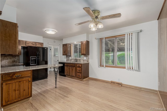 3334 W Grand Ave, Englewood, CO 80110 - kitchen with black appliances, tasteful backsplash, light wood-type flooring, and a ceiling fan