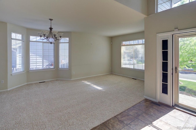 unfurnished room featuring carpet flooring, a chandelier, and baseboards