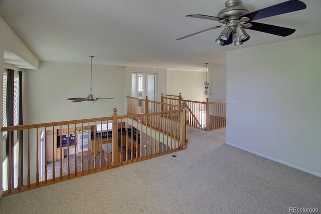 hallway featuring carpet floors, an upstairs landing, and baseboards
